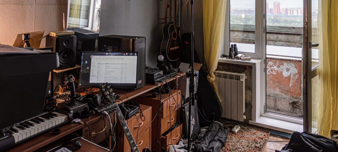 Hjemmestudio med gitarer, keyboard, høyttalere og musikkutstyr